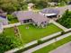 Aerial view of backyard featuring a large grassy area, screened porch, and white vinyl fence at 2808 Abbey Grove Dr, Valrico, FL 33594