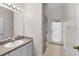 Bright bathroom with a single vanity, lots of light and walk-in shower, featuring an exterior door to outside at 2808 Abbey Grove Dr, Valrico, FL 33594