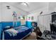 bedroom with blue accent wall and Star Wars-themed decorations, including figurines and posters at 2808 Abbey Grove Dr, Valrico, FL 33594