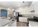 Well-equipped kitchen with stainless steel appliances, white cabinets, and wood-look tile flooring at 2808 Abbey Grove Dr, Valrico, FL 33594