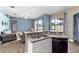 Open-concept kitchen and living space features a breakfast bar, stainless steel sink, and access to the backyard at 2808 Abbey Grove Dr, Valrico, FL 33594