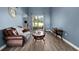 Comfortable living room with hardwood-style flooring, a leather couch, and a sliding glass door to the backyard at 2808 Abbey Grove Dr, Valrico, FL 33594