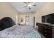 This spacious bedroom features a ceiling fan, dark wood trim, and an ensuite bathroom at 2808 Abbey Grove Dr, Valrico, FL 33594