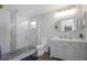 Bright bathroom features a glass-enclosed shower with modern fixtures, sleek vanity, and oval mirror, creating a spa-like retreat at 3035 Annadale, Brandon, FL 33511