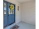 Close-up of a vibrant blue front door with decorative wreath, welcome mat and stylish house number at 3035 Annadale, Brandon, FL 33511