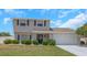 Charming two-story home boasts a blue door, complemented by a two-car garage and a well-manicured lawn at 3035 Annadale, Brandon, FL 33511