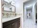 Bathroom with a speckled countertop and dark cabinetry next to a hallway with modern tiled floors at 30456 Willow Bank Ave, Brooksville, FL 34602