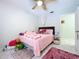 Bedroom featuring pink decor, ceiling fan, white walls, and a plush rug at 30456 Willow Bank Ave, Brooksville, FL 34602