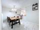 Dining room with light walls and floors, pendant lighting, and views to a white kitchen with stainless appliances at 30456 Willow Bank Ave, Brooksville, FL 34602