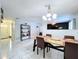 Bright dining room featuring white walls and floors, chandelier, and views to a living room and entryway at 30456 Willow Bank Ave, Brooksville, FL 34602