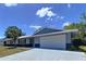 Home exterior with a gray exterior, two-car garage, and a well-maintained lawn at 30456 Willow Bank Ave, Brooksville, FL 34602