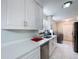 Updated kitchen with white cabinets, quartz countertops, and views to the washer and dryer at 30456 Willow Bank Ave, Brooksville, FL 34602