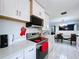 Bright kitchen featuring white cabinets, black appliances, and a cozy dining room area at 30456 Willow Bank Ave, Brooksville, FL 34602
