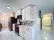 Bright kitchen featuring white cabinets, black appliances, and views to the entryway at 30456 Willow Bank Ave, Brooksville, FL 34602