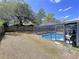Inviting screened-in pool with clear blue water, surrounded by a spacious patio area and lush green landscaping at 30456 Willow Bank Ave, Brooksville, FL 34602