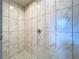 Walk-in shower featuring marble-look tile and black and white patterned floor at 30456 Willow Bank Ave, Brooksville, FL 34602