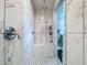 Walk-in shower featuring marble-look tile, rain shower head, and a convenient built-in bench at 30456 Willow Bank Ave, Brooksville, FL 34602
