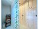 Tiled walk-in shower featuring modern fixtures and leaf-patterned shower curtain at 30456 Willow Bank Ave, Brooksville, FL 34602
