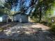 A view of the driveway leading to the side of the home, with a storage shed visible on the left at 3515 E 8Th Ave, Tampa, FL 33605
