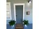 Classic front door with a welcome mat, accent plants, and updated light fixture at 3515 E 8Th Ave, Tampa, FL 33605