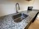 Close up shot of kitchen sink with granite countertops and stainless steel appliances at 3515 E 8Th Ave, Tampa, FL 33605