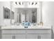 The primary bathroom features a double vanity with marble countertop and framed mirrors at 35519 Bellington Blvd, Zephyrhills, FL 33541