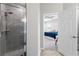 Modern bathroom featuring a tile shower, glass doors and view to the primary bedroom at 35519 Bellington Blvd, Zephyrhills, FL 33541