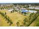 Aerial view of community amenities including pool, playground, large green space, and parking area at 35519 Bellington Blvd, Zephyrhills, FL 33541