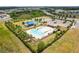 Aerial view showing the pool, playground, clubhouse, and parking in a green community setting at 35519 Bellington Blvd, Zephyrhills, FL 33541
