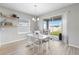 Cozy dining area with white table and chairs, complemented by backyard views through sliding glass doors to a lanai at 35519 Bellington Blvd, Zephyrhills, FL 33541