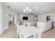 Bright dining room with white table, chairs, and chandelier, with view into the living room and kitchen at 35519 Bellington Blvd, Zephyrhills, FL 33541