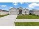 Charming single-story home with a gray exterior, a two-car garage, and a well-manicured lawn at 35519 Bellington Blvd, Zephyrhills, FL 33541