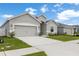 Charming single-story home with a gray exterior, a two-car garage, and a well-manicured lawn at 35519 Bellington Blvd, Zephyrhills, FL 33541
