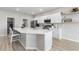 Modern kitchen with white cabinets, stainless steel appliances, quartz counters, and large center island with barstool seating at 35519 Bellington Blvd, Zephyrhills, FL 33541