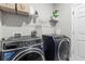 Convenient laundry room featuring modern washer and dryer units, and built-in shelving at 35519 Bellington Blvd, Zephyrhills, FL 33541