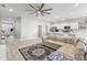 Bright and airy living room with modern ceiling fan open to kitchen and view of entryway with lots of natural light at 35519 Bellington Blvd, Zephyrhills, FL 33541