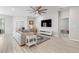 Cozy living room with a large TV, light wood floors, and an area rug at 35519 Bellington Blvd, Zephyrhills, FL 33541