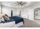 This primary bedroom features a tray ceiling with fan, plush carpet and ensuite bath at 35519 Bellington Blvd, Zephyrhills, FL 33541
