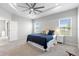 This primary bedroom features a tray ceiling with fan, plush carpet and large windows at 35519 Bellington Blvd, Zephyrhills, FL 33541