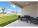 Inviting patio with outdoor seating and a view of the backyard and white picket fence at 35519 Bellington Blvd, Zephyrhills, FL 33541