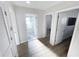 Hallway with light wood-look floors leads to several rooms including a bathroom with a glass shower at 4715 W Chapin Ave, Tampa, FL 33611