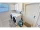 Convenient laundry room featuring a washer and dryer, storage cabinets, and direct access to the outside at 4715 W Chapin Ave, Tampa, FL 33611