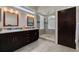 Modern bathroom with dark cabinets, double sinks, a glass-enclosed shower, and natural light at 4766 Royal Palm Ne Cir, St Petersburg, FL 33703