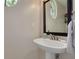 Pedestal sink in bathroom with a round mirror and a unique round window at 4766 Royal Palm Ne Cir, St Petersburg, FL 33703