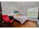 Bright bedroom featuring hardwood floors, a cozy bed, and a large window with natural light at 4766 Royal Palm Ne Cir, St Petersburg, FL 33703