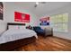 Bright bedroom showcasing two beds, hardwood floors, and a window with natural light at 4766 Royal Palm Ne Cir, St Petersburg, FL 33703