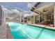 Beautiful blue pool surrounded by a screened-in enclosure and outdoor seating for relaxing at 4766 Royal Palm Ne Cir, St Petersburg, FL 33703
