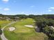 Aerial view of the golf course featuring lush greenery, sand traps, and ponds at 4946 Mill Pond Rd # 3180, Wesley Chapel, FL 33543