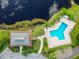 Aerial view of the community pool with the clubhouse next to a pond at 4946 Mill Pond Rd # 3180, Wesley Chapel, FL 33543