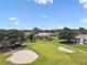 Aerial view of well-maintained golf course, sand traps, and the community's condo buildings at 4946 Mill Pond Rd # 3180, Wesley Chapel, FL 33543